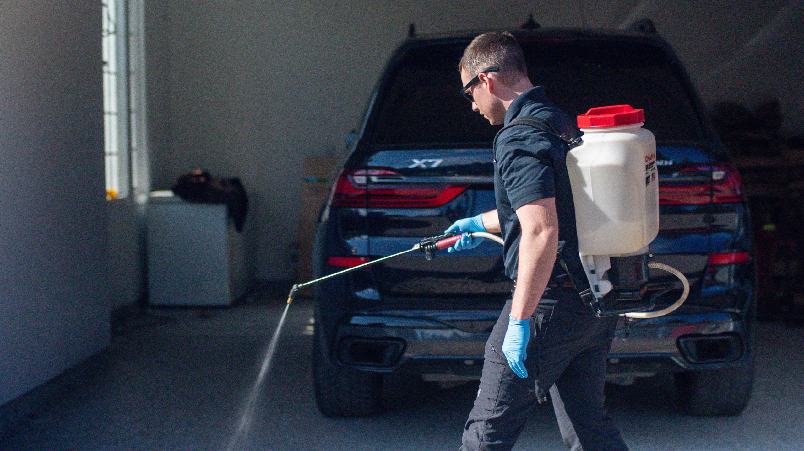 Bird Control; Forbearance Pest Control; pest control technician in blue uniform using a hand sprayer