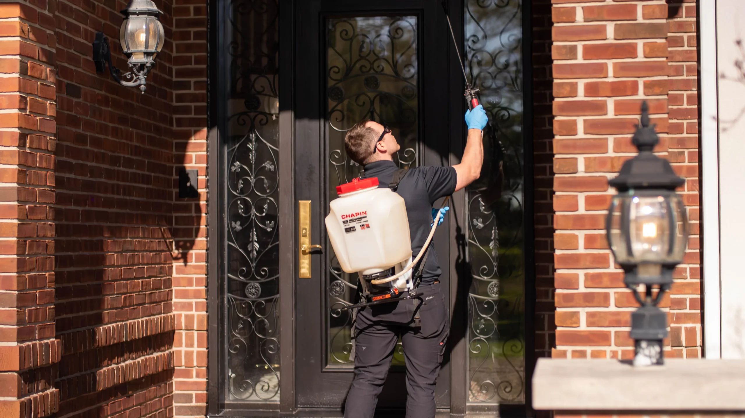 Ant Control Methods-Forbearance Pest Control-pest control technician spraying the front of a commercial building